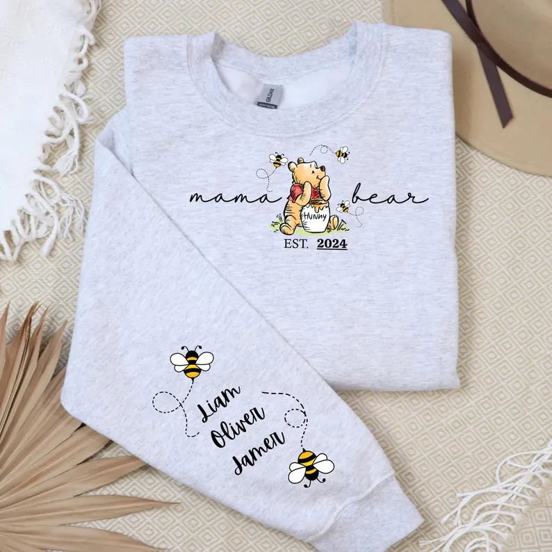 Grey sweatshirt with playful Winnie the Pooh and "momma bear" text, kids' names and Mickey Mouse icons on the sleeve.
